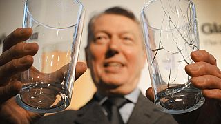 Former UK Home Secretary Alan Johnson holds two pint glasses in London, Thursday, Feb 2010.