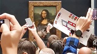 Охранник Лувра вытирает следы торта с защитного стекла на картине "Мона Лиза", 30 мая 2022 г.