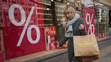 A woman walks with purchases past a store in Berlin, DEU, Friday, April 1, 2022.