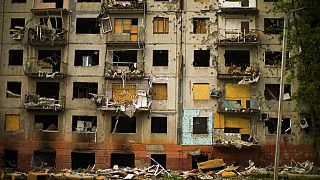 Debris hangs from a residential building heavily damaged in a Russian bombing earlier in the war in Kramatorsk, eastern Ukraine, Saturday, May 21, 2022