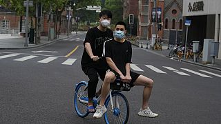 Dos jóvenes chinos salen a la calle tras un largo encierro por las restricciones de la pandemia