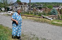 An elderly woman walks past a building damaged by an overnight missile strike in Sloviansk, Ukraine, Wednesday, June 1, 2022.