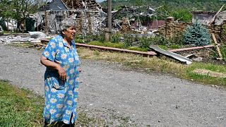 An elderly woman walks past a building damaged by an overnight missile strike in Sloviansk, Ukraine, Wednesday, June 1, 2022.