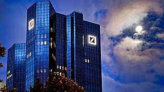 the moon shining next to the headquarters of the Deutsche Bank in Frankfurt, Germany, Oct.4, 2020.