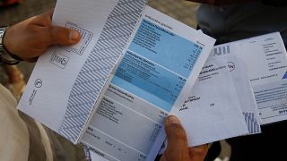 Καταναλωτής κρατάει λογαριασμό ρεύματος, πριν την εκδίκαση προσφυγής του ΙΝΚΑ για την ρήτρα αναπροσαρμογής, στα δικαστήρια της πρώην Σχολής Ευελπίδων στην Αθήνα