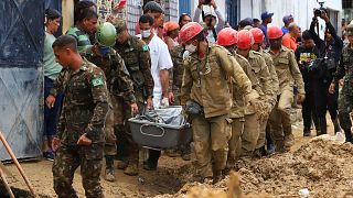 Des pompiers et des soldats retirent le corps d'une victime du glissement de terrain dans l'État de Pernambuco, au Brésil, 30 mai 2022.