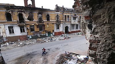 Children walk amid destroyed buildings in Mariupol which is Russian control in eastern Ukraine, Wednesday, May 25, 2022. 