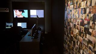 Eine Wand voll Bildern von Männern, die verdächtigt werden, im Netz für ein "zehnjähriges phillipinisches Sweetie" zu werben. Computeranimation, Terres des Hommes, Amsterdam