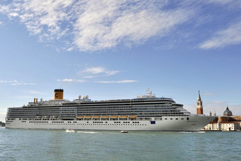 In this file photo, the Costa Deliziosa cruise ship sails past St. Mark's Square, visible in background at right, in Venice, Italy