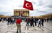 A man stands with a national flag as thousands of people visit the mausoleum of Mustafa Kemal Ataturk, the founder of modern Turkey, Thursday, May 19, 2022.