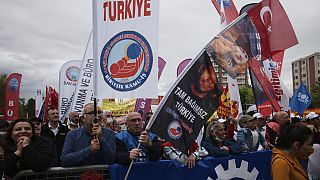 Tausende von Menschen schwenken Fahnen und Transparente während einer Mai-Demonstration in Ankara, Türkei, Sonntag, 1. Mai 2022