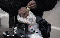 Эвакуированная из Мариуполя в Запорожье держит в руках пакет с медикаментами и иконой. Май, 2022 года