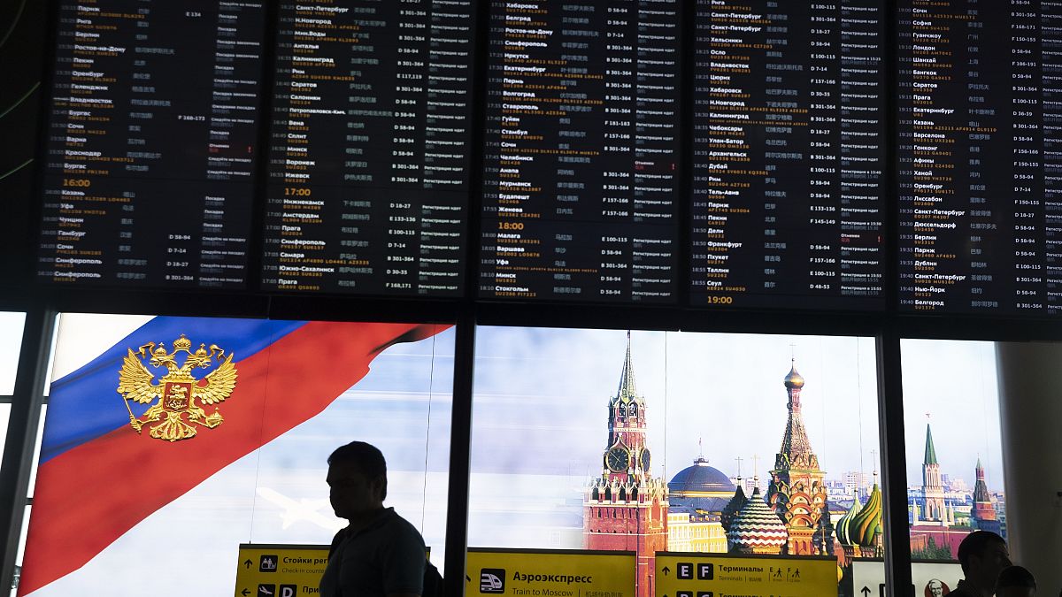 Viajeros pasan ante la pantalla de salidas del aeropuerto moscovita de Sheremetyevo 