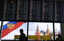 Viajeros pasan ante la pantalla de salidas del aeropuerto moscovita de Sheremetyevo