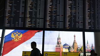 Viajeros pasan ante la pantalla de salidas del aeropuerto moscovita de Sheremetyevo