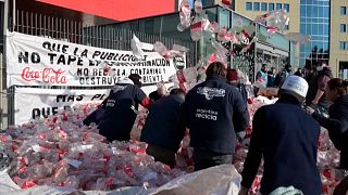 Garbage recyclers protest in front of Coca-Cola's office throwing Coca-Cola bottles in Buenos Aires.