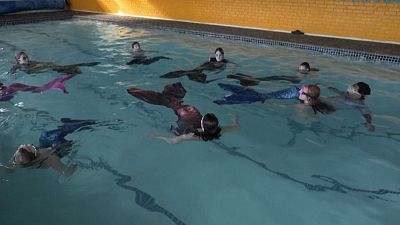 Mermaids doing exercises in the pool.