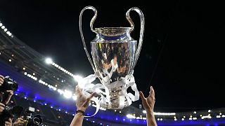 Real Madrid's Luka Modric is reflected in the trophy as he throws it in the air while celebrating with  team mates winning the Champions League final in Paris on 29 May 2022
