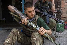 A security member of a medical rescue team cleans his weapon in the Donetsk, 4 June 2022