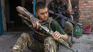 A security member of a medical rescue team cleans his weapon in the Donetsk, 4 June 2022