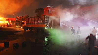 Des pompiers luttent contre un incendie dans l'entrepôt de Sitakunda au Bangladesh, dans la nuit de samedi à dimanche