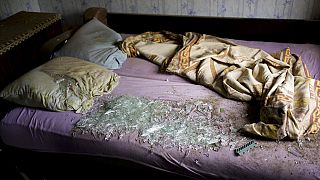 Осколки стекла на кровати в доме, пострадавшем после артобстрела Дружковки