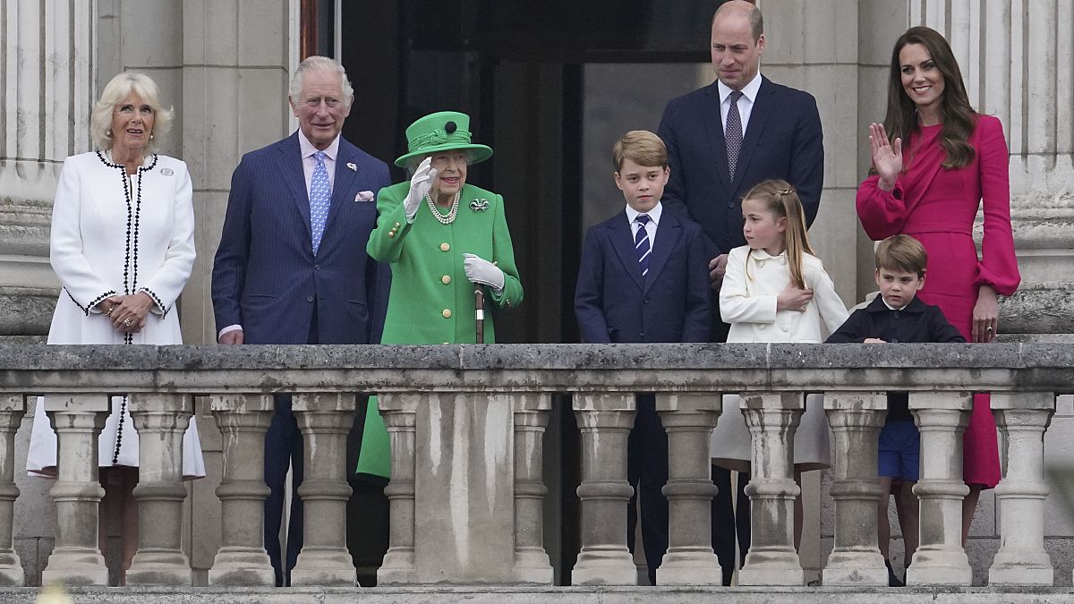 La reine Elizabeth II, accompagnée de son fils le prince Charles et son petit-fils William, salue ses sujets depuis le balcon de Buckingham Palace