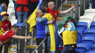 Accolade entre fans gallois et ukrainiens au Cardiff City Stadium, après la défaite 1-0 de l'Ukraine, synonyme d'élimination dans la course à la qualification au mondial 2022.