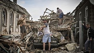 People clean the debris from their destroyed house after a missile strike, which killed an old woman, in the city of Druzhkivka, Ukraine's eastern Donbas region, June 5, 2022.