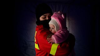 کودک اوکراینی در آغوش امدادگری حاضر در مرز رومانی