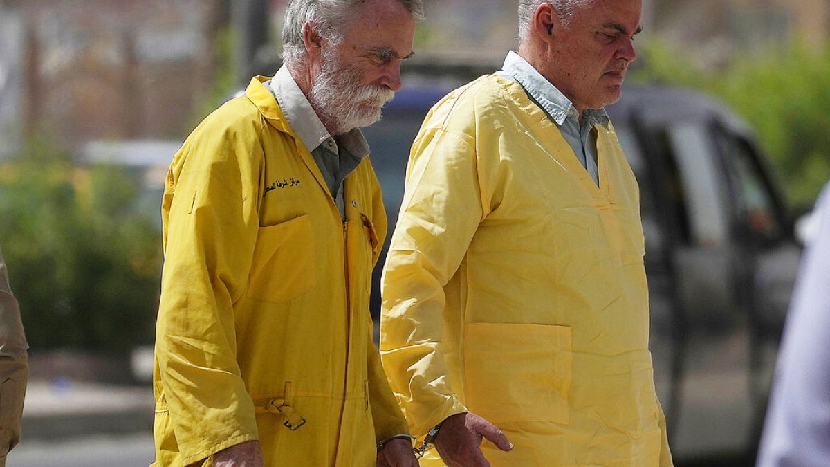 Jima Fitton (izquierda) y Volker Waldmann (derecha) llegan esposados al tribunal en Bagdad, Irak  22/5/2022