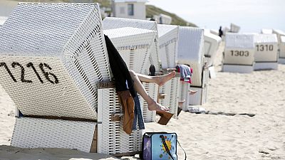 Visitantes sentados em cadeiras de praia na praia de Sylt, Westerland, Alemanha, quarta-feira, 1 de junho de 2022.