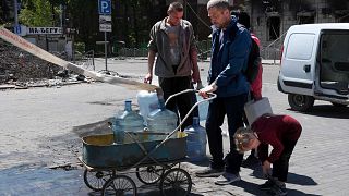 السكان يملؤون زجاجات بمياه الشرب في ماريوبول، شرق أوكرانيا، الخميس 12 مايو 2022