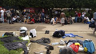 Migrantes em frente ao complexo desportivo de Álvaro Obregón, utilizado como centro de acolhimento. -