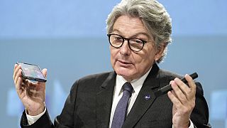 EU Commissioner for the internal market, Thierry Breton, holding two smartphones.