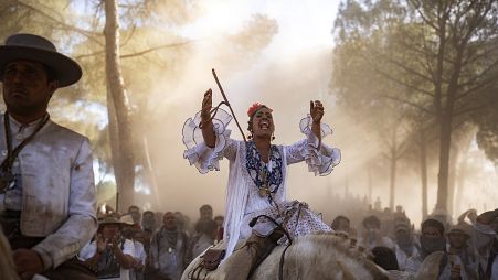 A pilgrim rides her horse in the Donana National Park on their way to the shrine of El Rocio in Almonte, Spain, on Friday, June 3, 2022