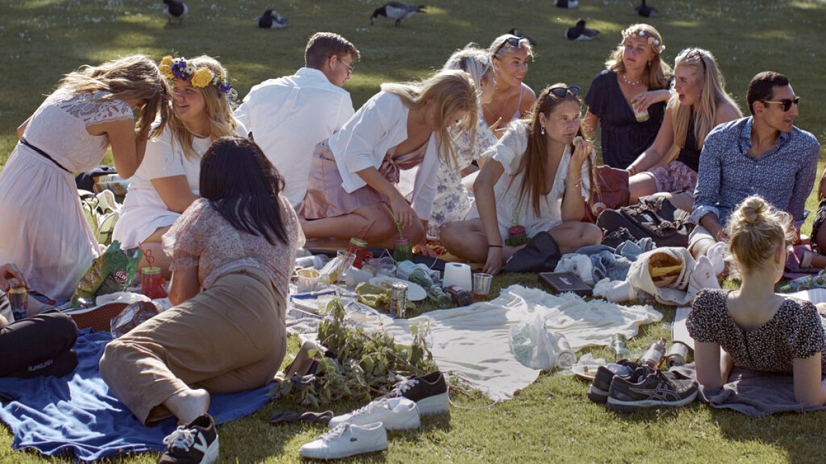 A 2020 júniusában készült képen Szentiván napján piknikeznek együtt svédek egy stockholmi parkban