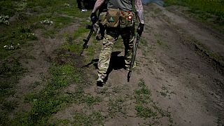 Un miliciano civil sostiene una escopeta y un rifle durante un entrenamiento en un campo de tiro en las afueras de Kiev, Ucrania, el martes 7 de junio de 2022