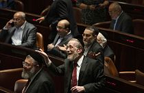 Lawmakers celebrate the defeat of a law on the legal status of Jewish settlers in the occupied West Bank, during a session of the Knesset, Israel's parliament, in Jerusalem