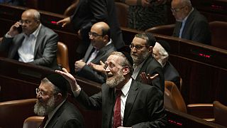 Lawmakers celebrate the defeat of a law on the legal status of Jewish settlers in the occupied West Bank, during a session of the Knesset, Israel's parliament, in Jerusalem