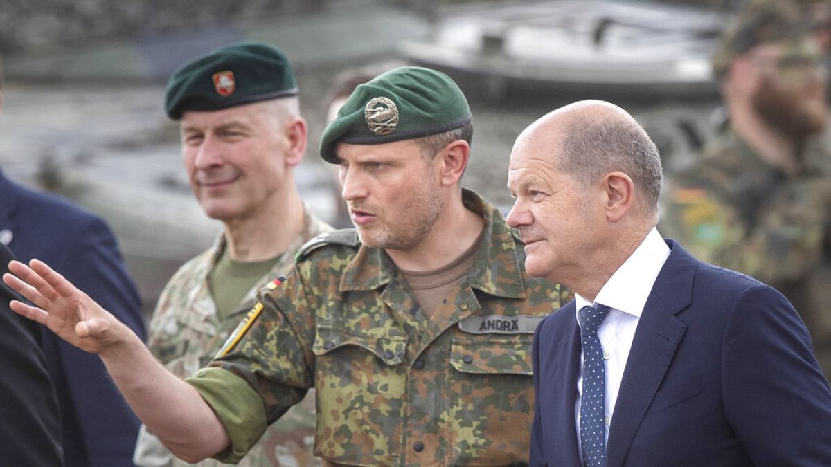 Olaf Scholz német kancellár (jobbra) hallgatja Daniel Andra litván NATO-parancsnokot Vilniusban