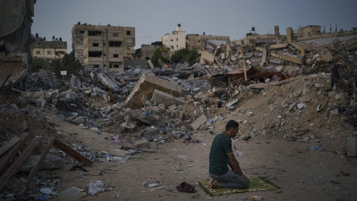 Izrael és a Hamász 11 napos háborújában szétlőtt otthona helyén imádkozik egy palesztin