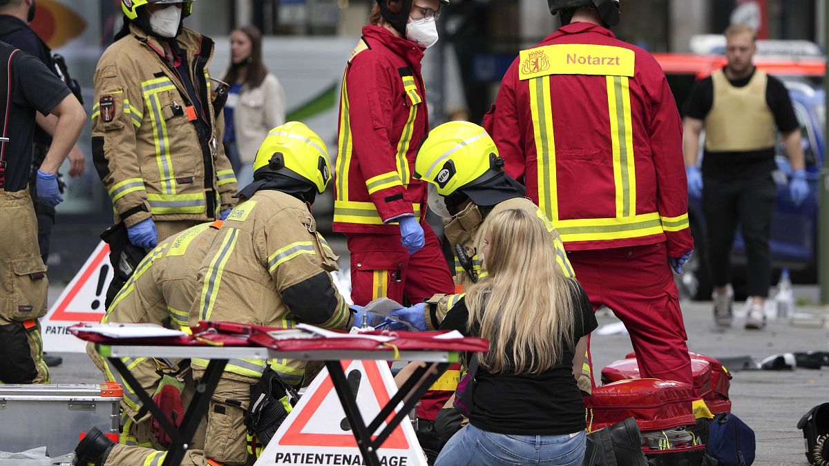 Rescue workers help an injured person after a car crashed into a crowd of people in central Berlin, Germany, Wednesday, June 8, 2022.