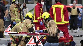 Rescue workers help an injured person after a car crashed into a crowd of people in central Berlin, Germany, Wednesday, June 8, 2022.