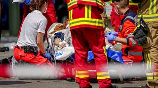 Mentősök az egyik sérültet látják el a baleset helyszínén 2022. június 8-án