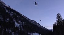 Rescue search workers are suspended from a helicopter ferrying searchers to the scene of an avalanche.  February 2019.
