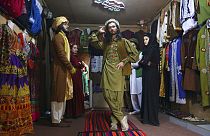 Ajmal Hakikii'nin yanında çalışan mankerler geleneksel Afgan kıyafetlerini sergilerken / Arşiv