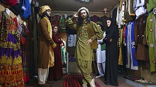 Ajmal Hakikii'nin yanında çalışan mankerler geleneksel Afgan kıyafetlerini sergilerken / Arşiv