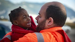 A child is carried by a member of Spain's Maritime Rescue Service as they arrive at the port of San Roque, southern Spain. October 2018