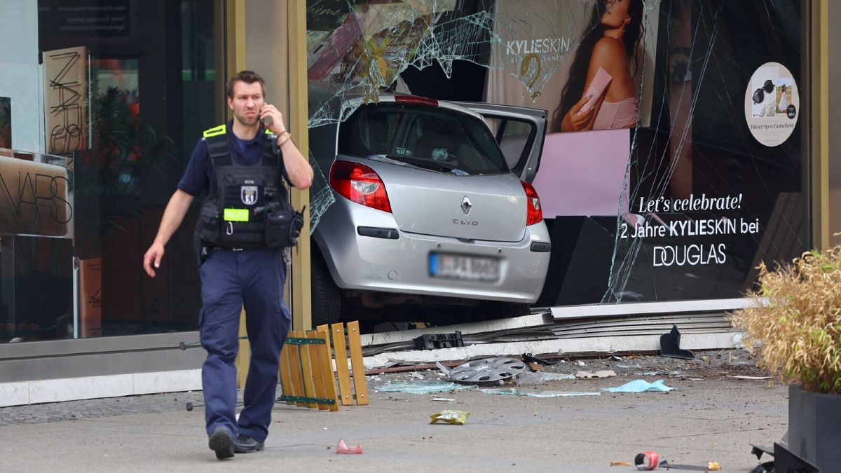 A car is seen in a shop window after crashing into a group of people near Breitscheidplatz in Berlin, Germany, June 8, 2022